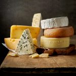 Various,Types,Of,Cheese,On,Rustic,Wooden,Table